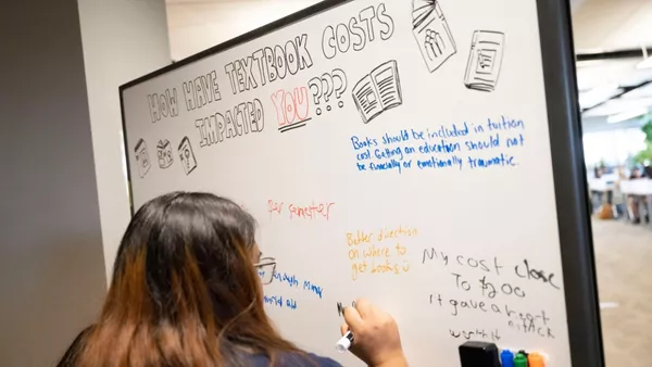 Image of a female student writing on a whiteboard